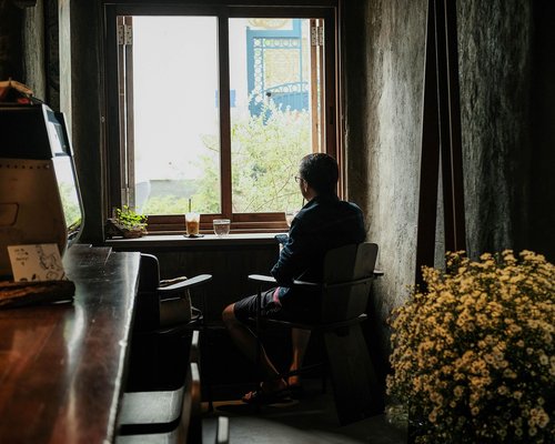 Person looking away from desk out a window